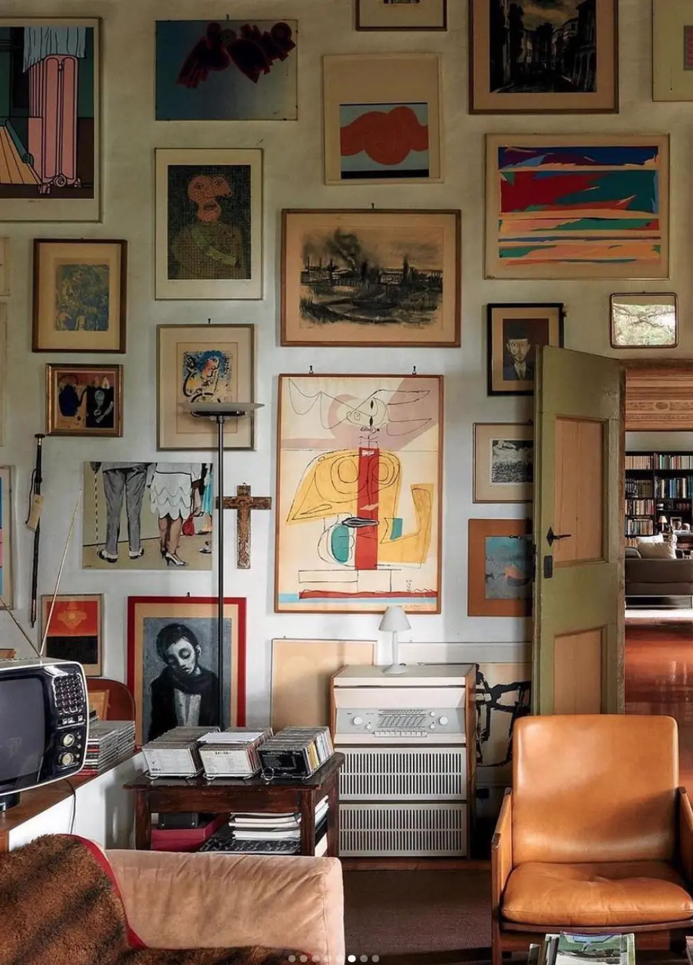 A collected interior: a wall of framed art and travel mementos